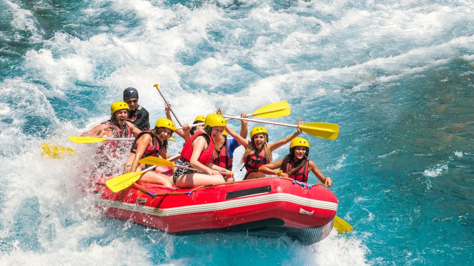 A raft crew paddling through white water rapids